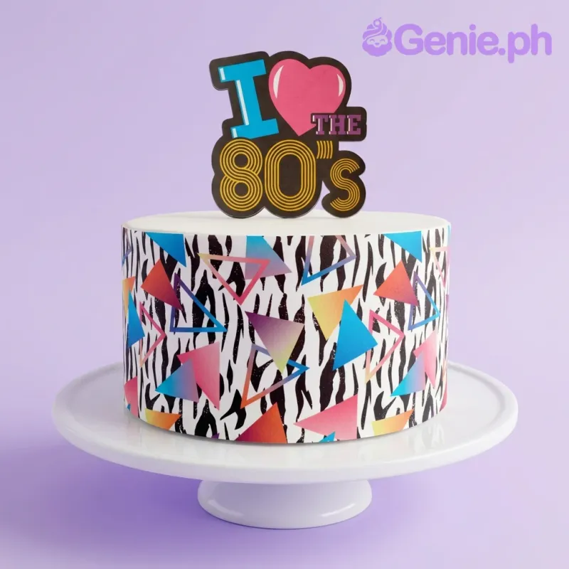 Retro 80s themed cake with zebra print sides, neon geometric triangles, and an I Love the 80s topper. Retro 80s themed cake with zebra print sides, neon geometric triangles, and an I Love the 80s topper.