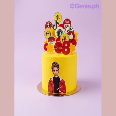 One tier yellow cake with circular logo printouts, a number eight, a photo of a person, yellow stars, and a YouTube logo sticker One tier yellow cake with circular logo printouts, a number eight, a photo of a person, yellow stars, and a YouTube logo sticker