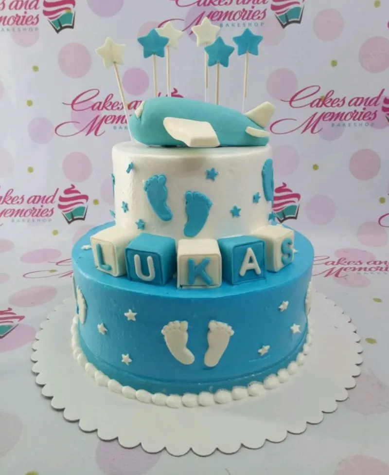 Two-tier blue and white airplane themed cake with fondant baby footprints, stars, and name blocks for Lukas. Two-tier blue and white airplane themed cake with fondant baby footprints, stars, and name blocks for Lukas.
