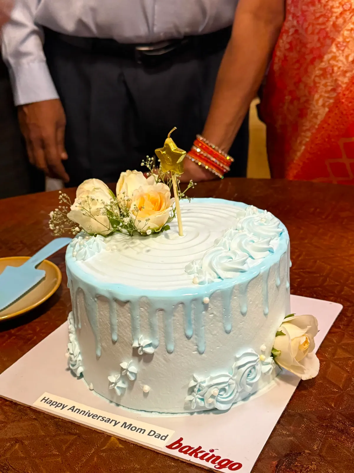 Light blue 1-tier cake with soft icing, a blue drip, fresh white roses, and a star candle Light blue 1-tier cake with soft icing, a blue drip, fresh white roses, and a star candle