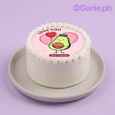 A white 1-tier cake themed for Mother's Day, featuring an avocado character printout and white icing rosettes. A white 1-tier cake themed for Mother's Day, featuring an avocado character printout and white icing rosettes.