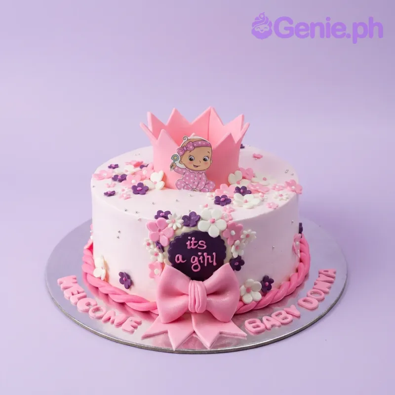 Pink baby girl cake with a pink crown, baby printout, fondant flowers, and a large pink bow. Pink baby girl cake with a pink crown, baby printout, fondant flowers, and a large pink bow.