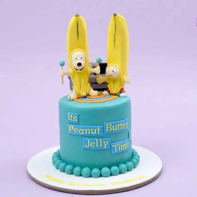 Teal 1-tier fondant cake with banana character toppers and Peanut Butter Jelly Time text panels Teal 1-tier fondant cake with banana character toppers and Peanut Butter Jelly Time text panels