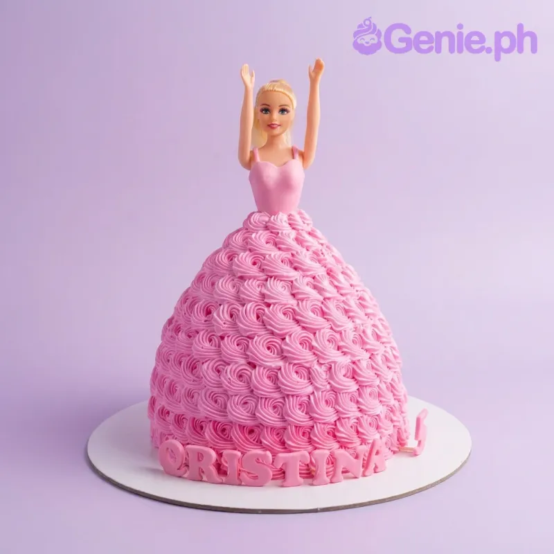 Barbie doll cake with a voluminous pink icing rosette dress and personalized name on the base board. Barbie doll cake with a voluminous pink icing rosette dress and personalized name on the base board.