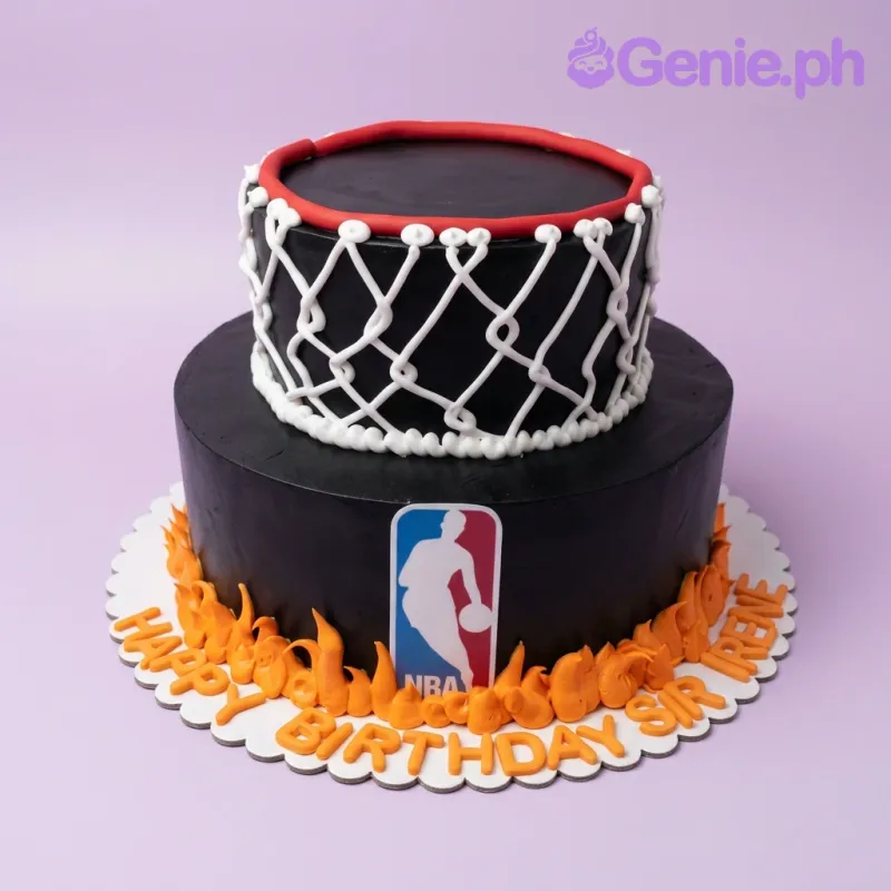 Black 2-tier basketball themed cake with a white icing net on the top tier and orange icing flames at the base. Black 2-tier basketball themed cake with a white icing net on the top tier and orange icing flames at the base.