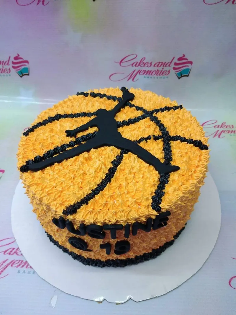 Orange basketball-themed cake with black Jordan Jumpman logo and textured icing rosettes. Orange basketball-themed cake with black Jordan Jumpman logo and textured icing rosettes.