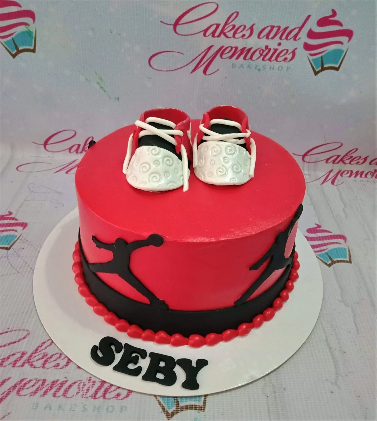 Red and black basketball themed cake with fondant baby shoes and Jordan silhouettes for Seby's birthday. Red and black basketball themed cake with fondant baby shoes and Jordan silhouettes for Seby's birthday.
