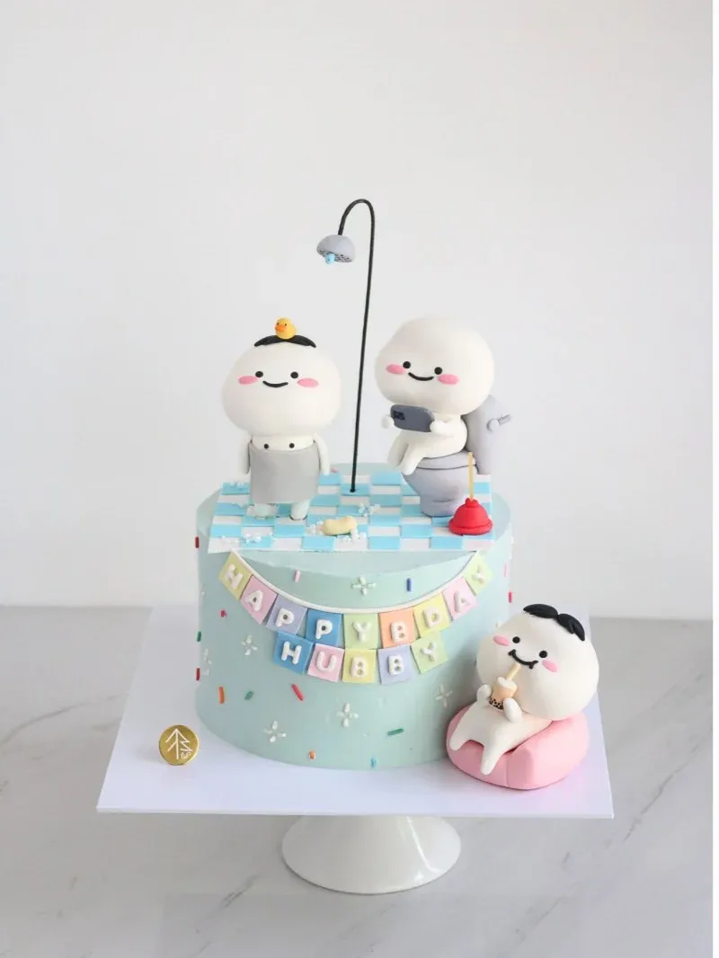 Light blue 1-tier cake with soft icing, three cute character figurines, a shower head, and a Happy Birthday Hubby banner Light blue 1-tier cake with soft icing, three cute character figurines, a shower head, and a Happy Birthday Hubby banner