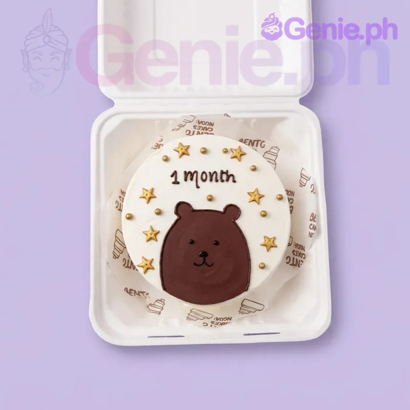 A white bento cake themed around Bear 1 Month, featuring a brown bear face, gold stars, and '1 month' text. A white bento cake themed around Bear 1 Month, featuring a brown bear face, gold stars, and '1 month' text.