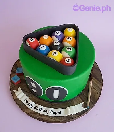 A green 1-tier fondant cake, Billiard Pool themed, with numbered pool balls in a rack and a cue stick. A green 1-tier fondant cake, Billiard Pool themed, with numbered pool balls in a rack and a cue stick.