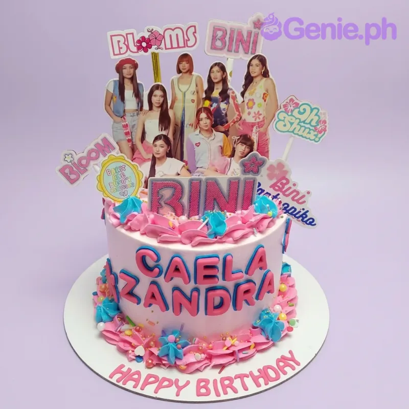 A pink 1-tier cake themed around BINI Kpop, featuring BINI group and logo printouts, with icing swirls and colorful sprinkles. A pink 1-tier cake themed around BINI Kpop, featuring BINI group and logo printouts, with icing swirls and colorful sprinkles.