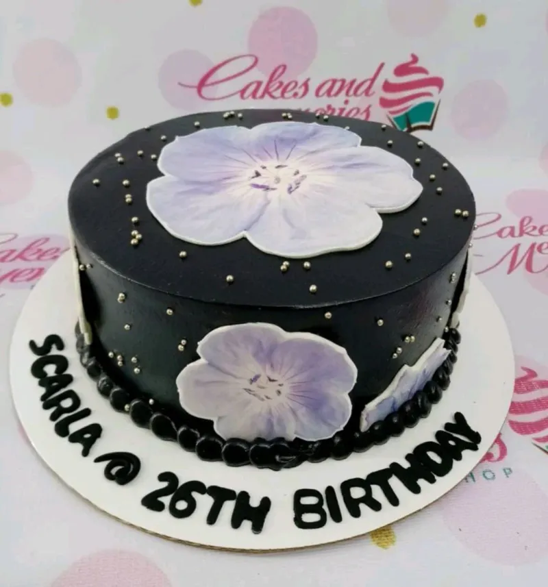A black, purple, and silver 1-tier cake themed Black Floral, featuring purple flower printouts, silver dragees, and 'SCARLA @ 26TH BIRTHDAY' text. A black, purple, and silver 1-tier cake themed Black Floral, featuring purple flower printouts, silver dragees, and 'SCARLA @ 26TH BIRTHDAY' text.