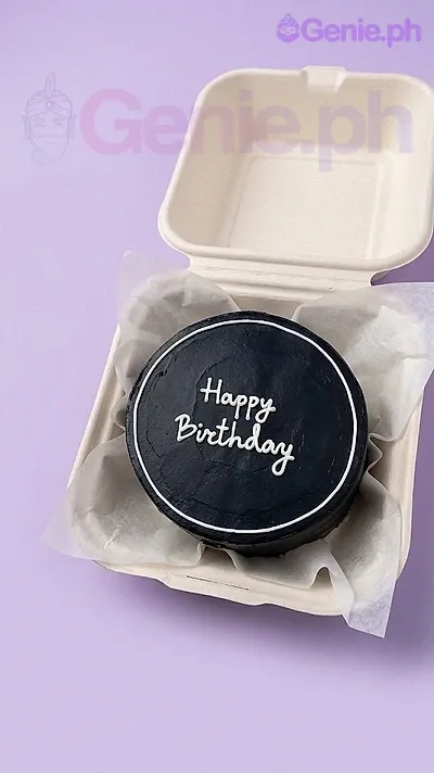 A black and white Bento cake themed around minimalism, featuring a white piped 'Happy Birthday' message and a white circular border. A black and white Bento cake themed around minimalism, featuring a white piped 'Happy Birthday' message and a white circular border.