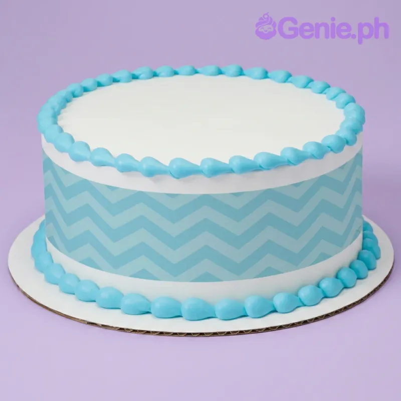 A white round cake with a blue chevron pattern side wrap, and blue icing teardrop borders on the top and base. A white round cake with a blue chevron pattern side wrap, and blue icing teardrop borders on the top and base.