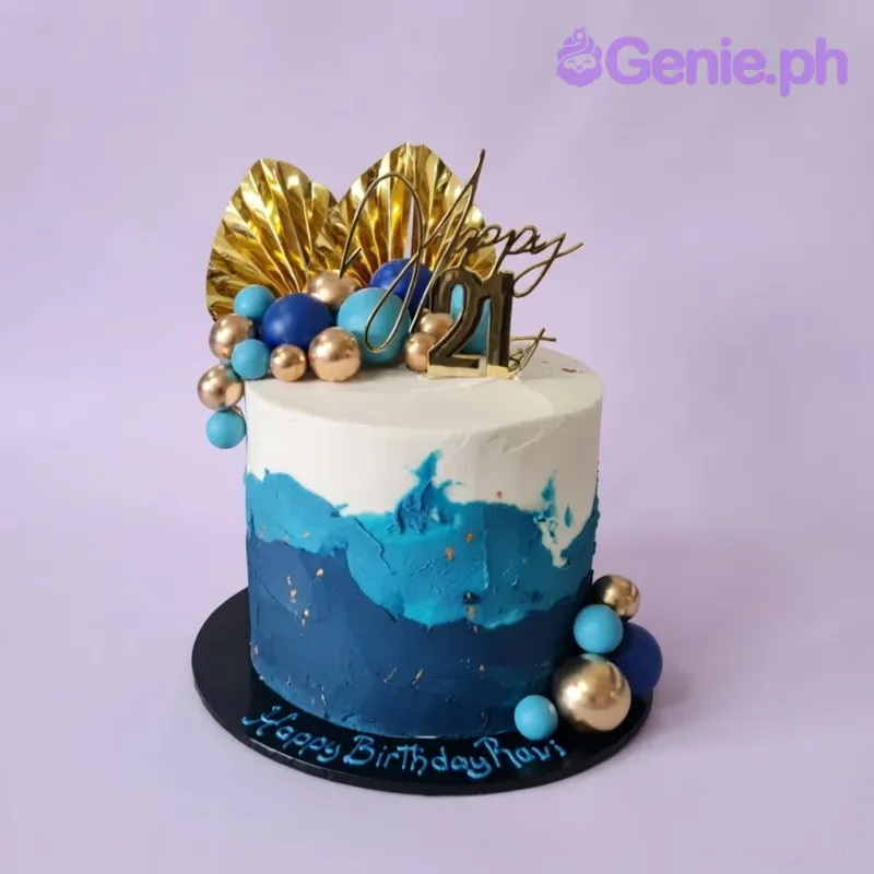 Navy blue 1-tier cake with soft icing, gold fan palm leaves, and gold and blue spherical balls Navy blue 1-tier cake with soft icing, gold fan palm leaves, and gold and blue spherical balls
