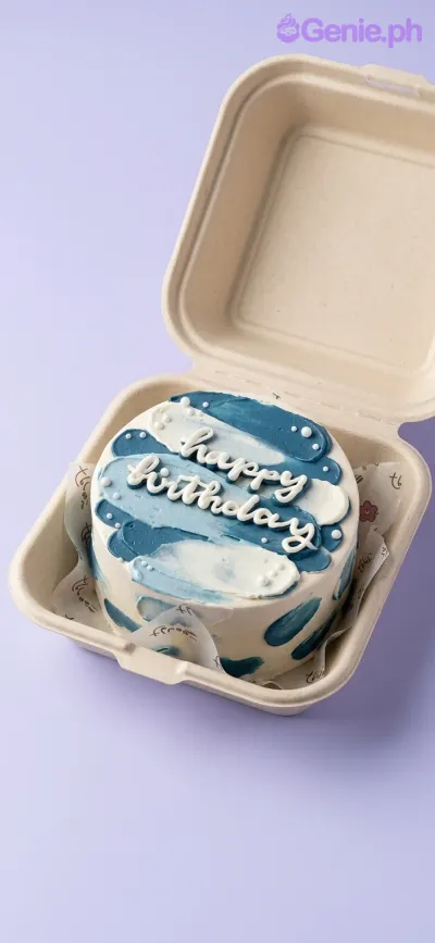 A blue and white Bento cake with minimalist palette knife icing strokes, a white 'Happy Birthday' message, and white sugar pearls. A blue and white Bento cake with minimalist palette knife icing strokes, a white 'Happy Birthday' message, and white sugar pearls.