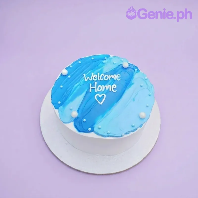A blue and light blue 1-tier cake themed around Blue Minimalist, featuring palette knife icing, white pearls, and a 'Welcome Home' message. A blue and light blue 1-tier cake themed around Blue Minimalist, featuring palette knife icing, white pearls, and a 'Welcome Home' message.