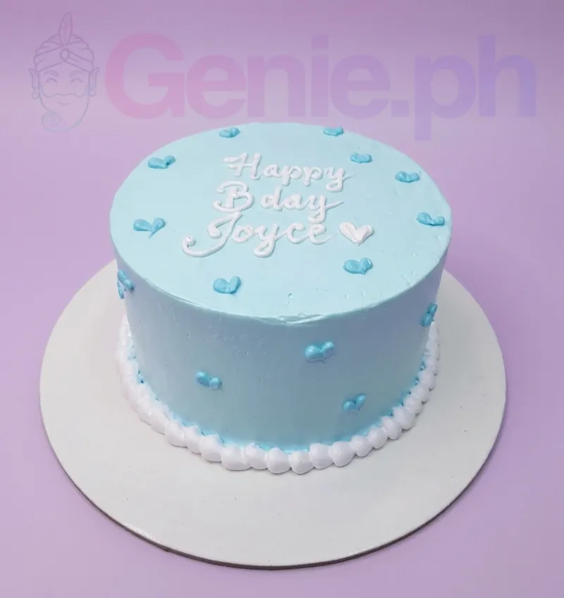 A light blue and white 1-tier cake themed around Blue Minimalist, featuring a white piped 'Happy Bday Joyce' message and small blue icing hearts. A light blue and white 1-tier cake themed around Blue Minimalist, featuring a white piped 'Happy Bday Joyce' message and small blue icing hearts.