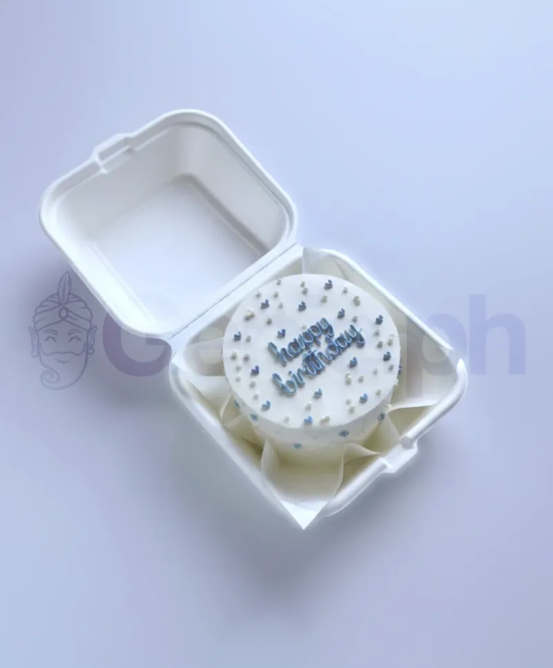 A white bento cake themed around Blue Minimalist, featuring blue and white heart sprinkles and a blue piped 'Happy Birthday' message. A white bento cake themed around Blue Minimalist, featuring blue and white heart sprinkles and a blue piped 'Happy Birthday' message.