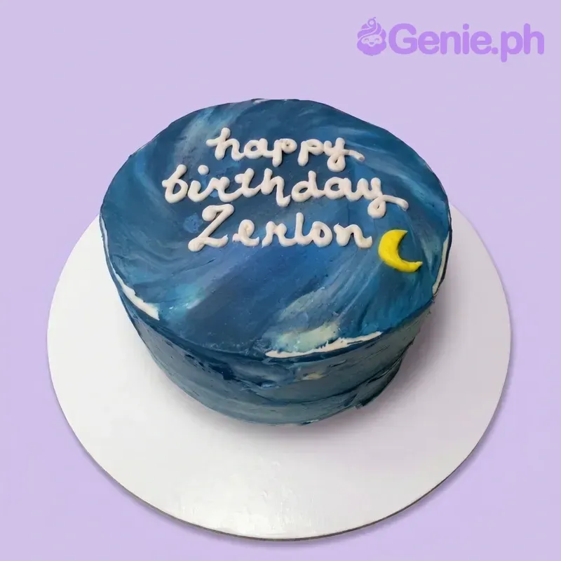 A dark blue 1-tier cake themed around a Blue Night Sky, featuring a yellow crescent moon and white piped text. A dark blue 1-tier cake themed around a Blue Night Sky, featuring a yellow crescent moon and white piped text.