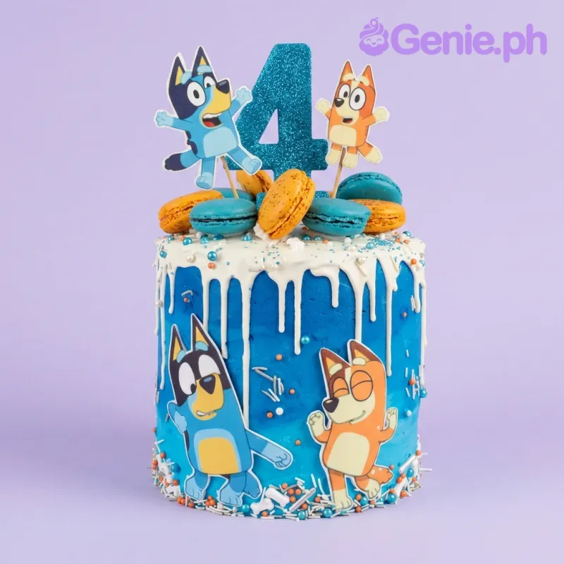 A blue and white 1 Tier cake, Bluey-themed, with Bluey and Bingo character toppers, a blue number 4, white drip, and macarons. A blue and white 1 Tier cake, Bluey-themed, with Bluey and Bingo character toppers, a blue number 4, white drip, and macarons.