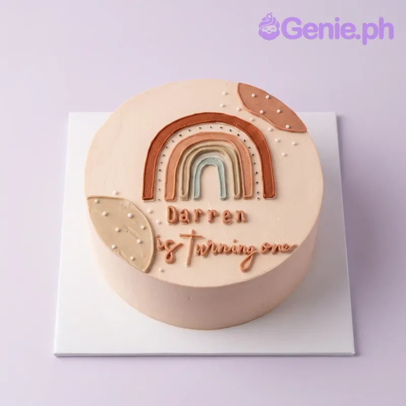 A white, terracotta, and tan 1-tier cake themed around Boho Rainbow, featuring a piped icing rainbow and personalized text. A white, terracotta, and tan 1-tier cake themed around Boho Rainbow, featuring a piped icing rainbow and personalized text.