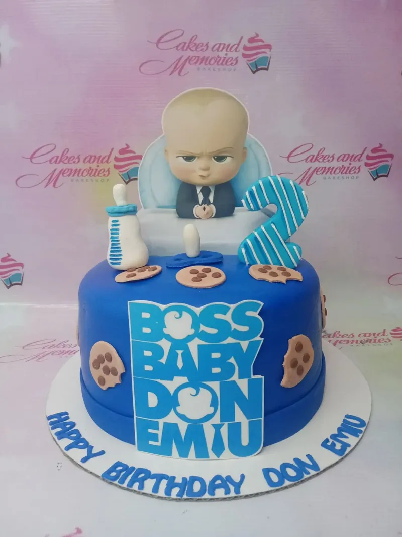 Blue Boss Baby themed fondant cake with a 3D baby figure, cookies, and a blue number two topper. Blue Boss Baby themed fondant cake with a 3D baby figure, cookies, and a blue number two topper.