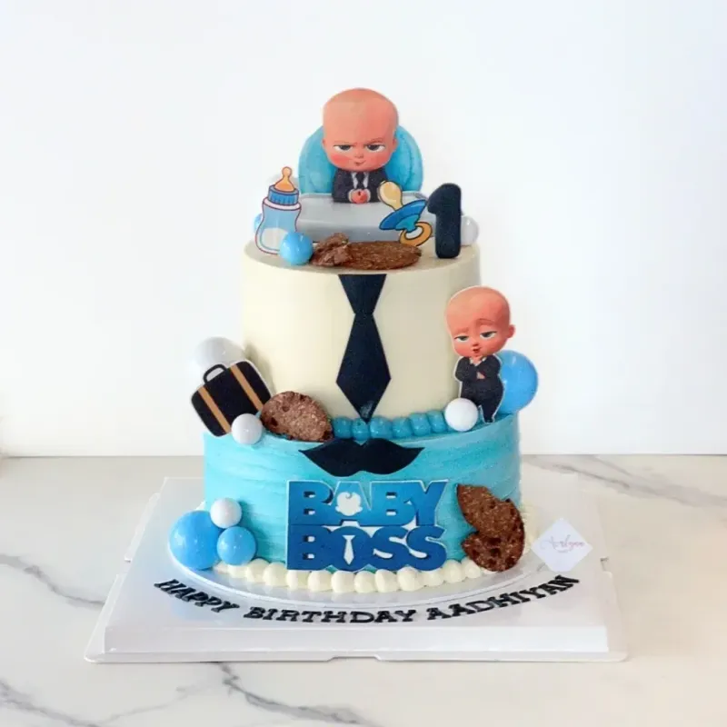 Light blue and ivory 2-tier soft icing birthday cake with Boss Baby character printouts, blue spheres, and a black necktie Light blue and ivory 2-tier soft icing birthday cake with Boss Baby character printouts, blue spheres, and a black necktie