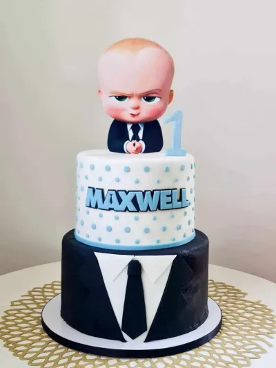 Boss Baby 2-tier fondant birthday cake with a portrait topper, suit decoration, and blue polka dots Boss Baby 2-tier fondant birthday cake with a portrait topper, suit decoration, and blue polka dots
