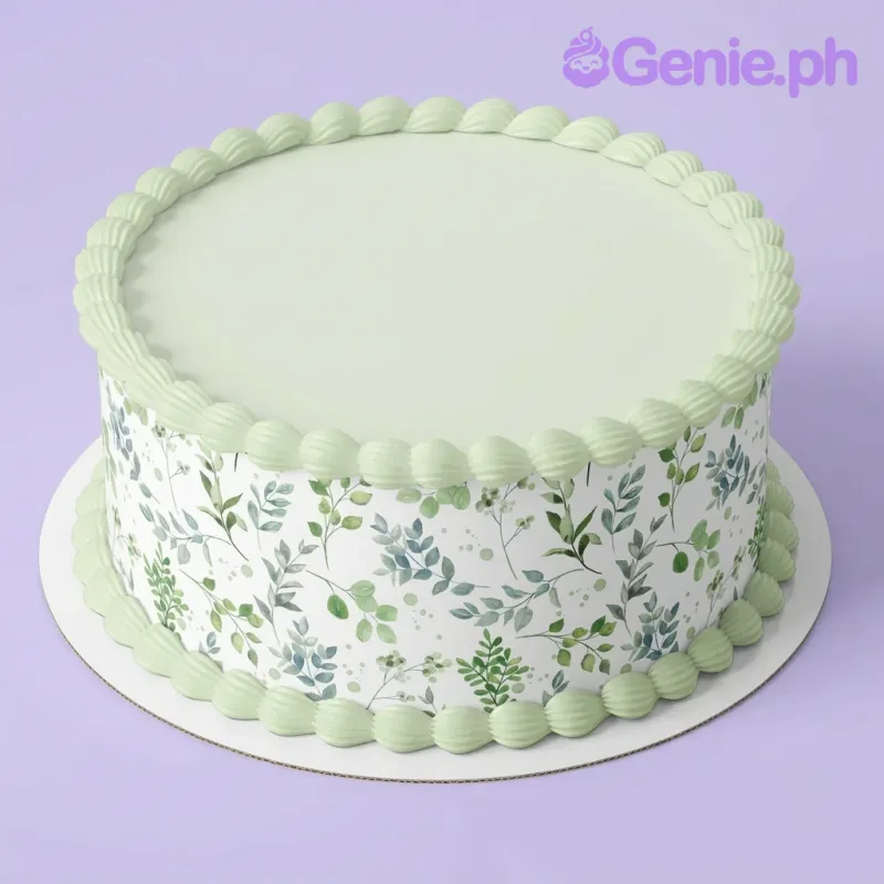 A white, green, and light green single tier cake themed around Botanical Leaf, featuring a green leaf pattern wrap and light green piped icing borders on top and base. A white, green, and light green single tier cake themed around Botanical Leaf, featuring a green leaf pattern wrap and light green piped icing borders on top and base.