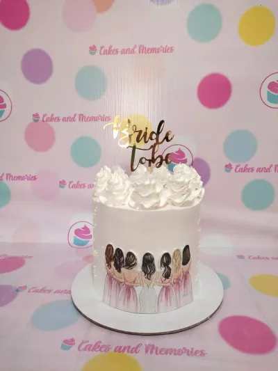 White 1-tier cake with smooth soft icing, a gold bride to be topper, and a bridesmaids printout wrap White 1-tier cake with smooth soft icing, a gold bride to be topper, and a bridesmaids printout wrap