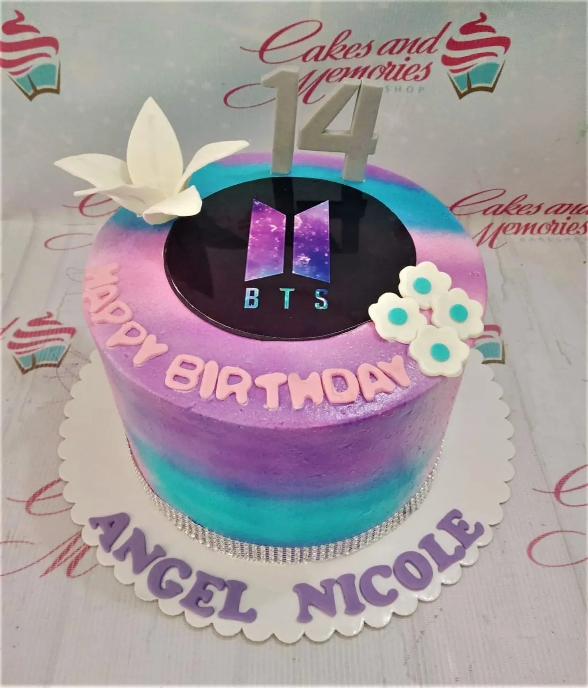 Purple and blue gradient BTS themed birthday cake with a 14th birthday topper and white fondant flowers. Purple and blue gradient BTS themed birthday cake with a 14th birthday topper and white fondant flowers.