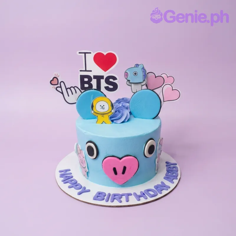 A light blue 1 Tier BTS K-pop themed cake, featuring an "I Love BTS" banner, character printouts, and a large pink heart nose. A light blue 1 Tier BTS K-pop themed cake, featuring an "I Love BTS" banner, character printouts, and a large pink heart nose.