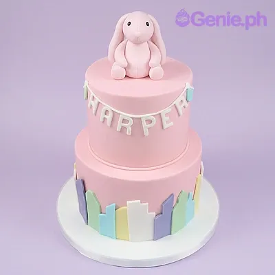 Pink 2-tier fondant cake with a bunny figurine topper and colorful vertical panels Pink 2-tier fondant cake with a bunny figurine topper and colorful vertical panels