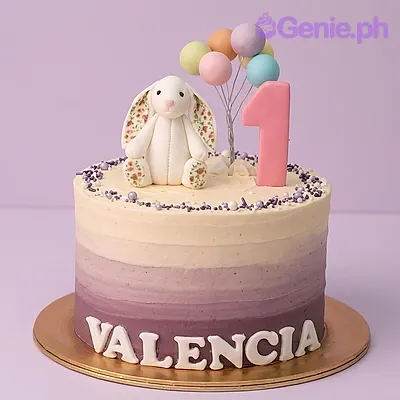 Ombre purple and pink 1st birthday cake with a bunny topper and number one candle Ombre purple and pink 1st birthday cake with a bunny topper and number one candle