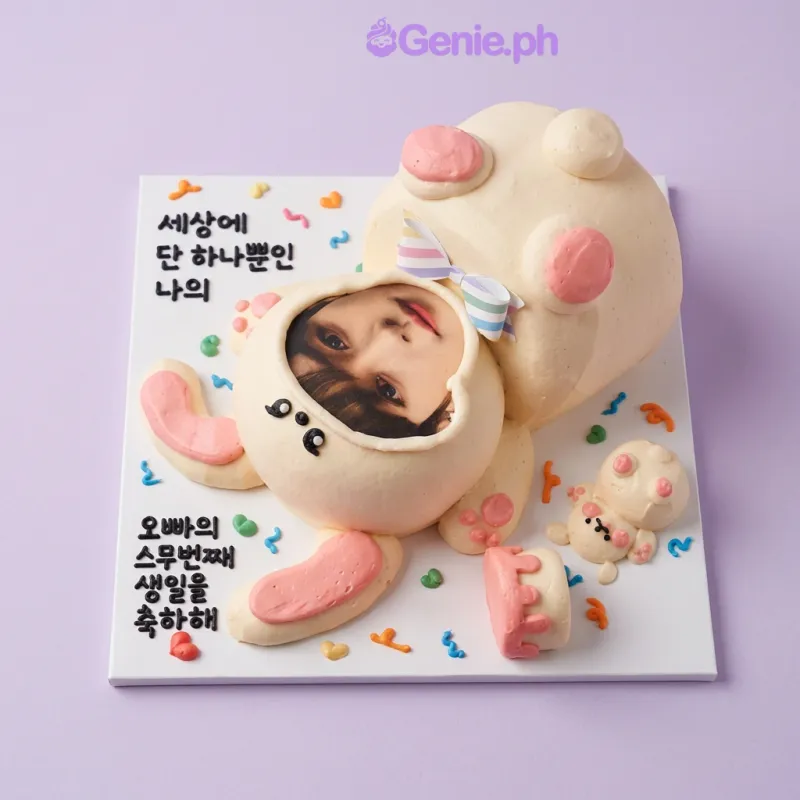 Light yellow bunny-shaped cake with a photo of a person's face, fondant ears, and a small cake topper with a candle Light yellow bunny-shaped cake with a photo of a person's face, fondant ears, and a small cake topper with a candle