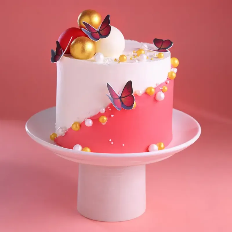 White and pink 1-tier cake with gold and red spheres and butterfly cutouts White and pink 1-tier cake with gold and red spheres and butterfly cutouts