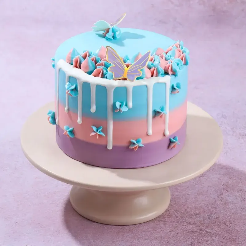 Blue pink and purple gradient cake with white drip and butterfly cutouts Blue pink and purple gradient cake with white drip and butterfly cutouts