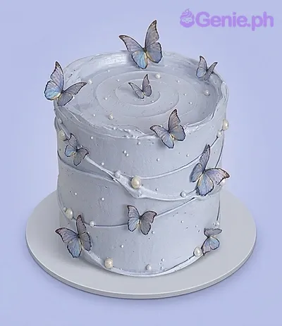A lavender purple 1-tier cake themed around Butterfly Lavender, featuring blue and purple butterfly printouts and white pearl sprinkles. A lavender purple 1-tier cake themed around Butterfly Lavender, featuring blue and purple butterfly printouts and white pearl sprinkles.