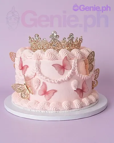A pink 1 Tier cake themed around Butterfly Princess, featuring a gold rhinestone crown, pink and gold butterflies, and piped icing ruffles. A pink 1 Tier cake themed around Butterfly Princess, featuring a gold rhinestone crown, pink and gold butterflies, and piped icing ruffles.