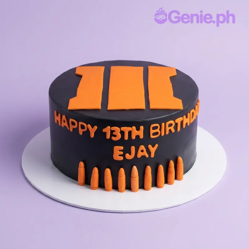 A black and orange 1 Tier Fondant cake themed around Call of Duty, featuring an orange Black Ops III logo, fondant bullets, and a birthday message. A black and orange 1 Tier Fondant cake themed around Call of Duty, featuring an orange Black Ops III logo, fondant bullets, and a birthday message.