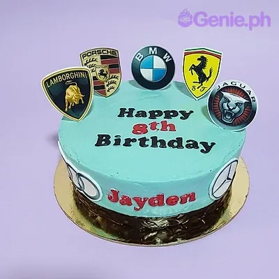 A light blue 1-tier Car Logo cake, featuring various luxury car brand printouts and red icing text. A light blue 1-tier Car Logo cake, featuring various luxury car brand printouts and red icing text.