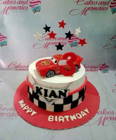 Disney Cars Lightning McQueen themed birthday cake with checkered flag pattern and star toppers Disney Cars Lightning McQueen themed birthday cake with checkered flag pattern and star toppers