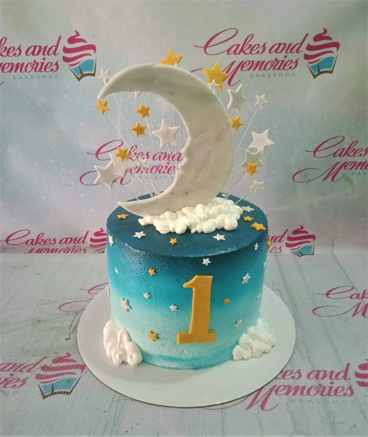 Blue gradient ombre cake with a large white crescent moon, yellow and white stars, and fluffy white icing clouds. Blue gradient ombre cake with a large white crescent moon, yellow and white stars, and fluffy white icing clouds.