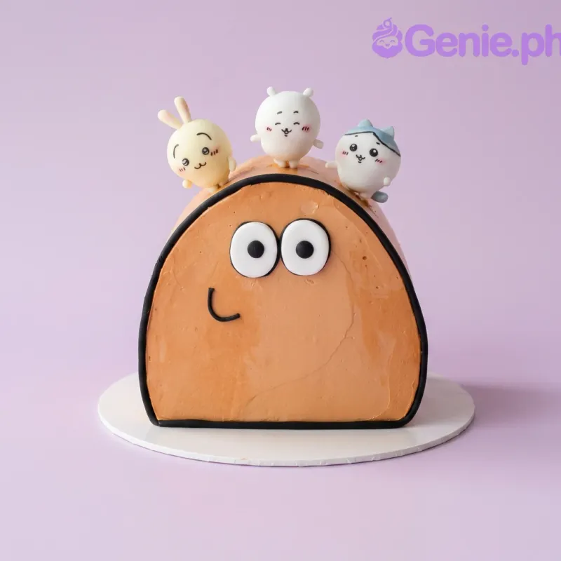 Tan dome-shaped cake with three cute character figures on top and piped face details Tan dome-shaped cake with three cute character figures on top and piped face details