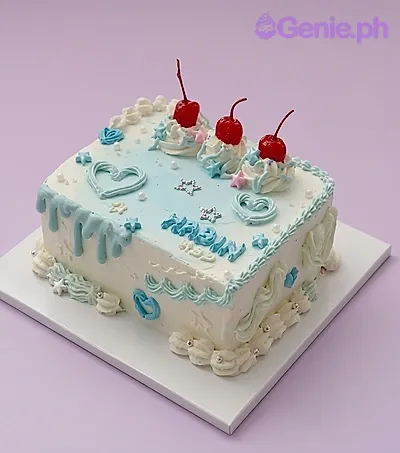 Rectangular cake with blue and white gradient icing, cherry toppers, and piped heart and star decorations Rectangular cake with blue and white gradient icing, cherry toppers, and piped heart and star decorations