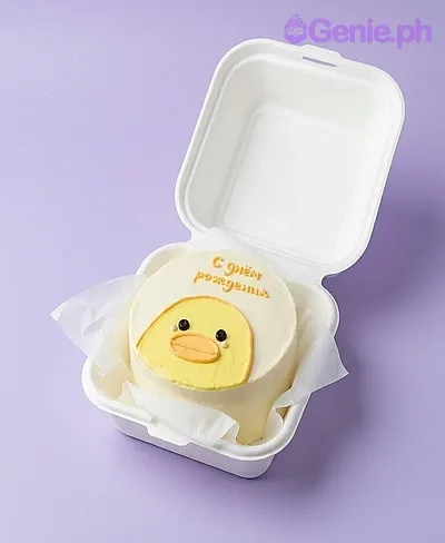 A white and yellow Bento cake themed around a chick, featuring an orange beak, black eyes, pink cheeks, and an orange Russian message. A white and yellow Bento cake themed around a chick, featuring an orange beak, black eyes, pink cheeks, and an orange Russian message.