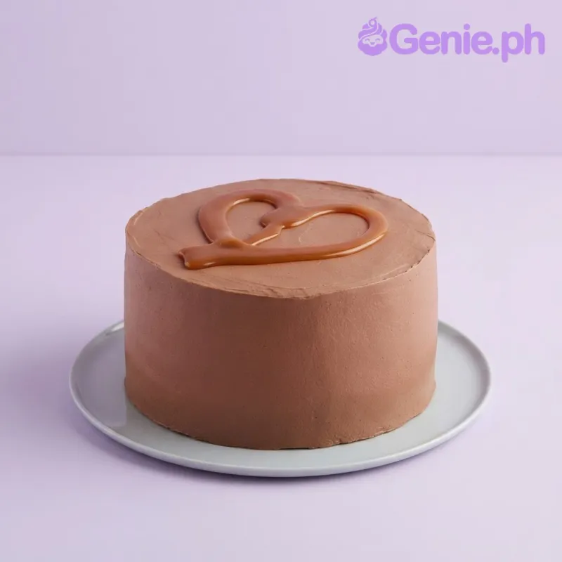Brown 1-tier cake with smooth soft icing being drizzled with caramel Brown 1-tier cake with smooth soft icing being drizzled with caramel