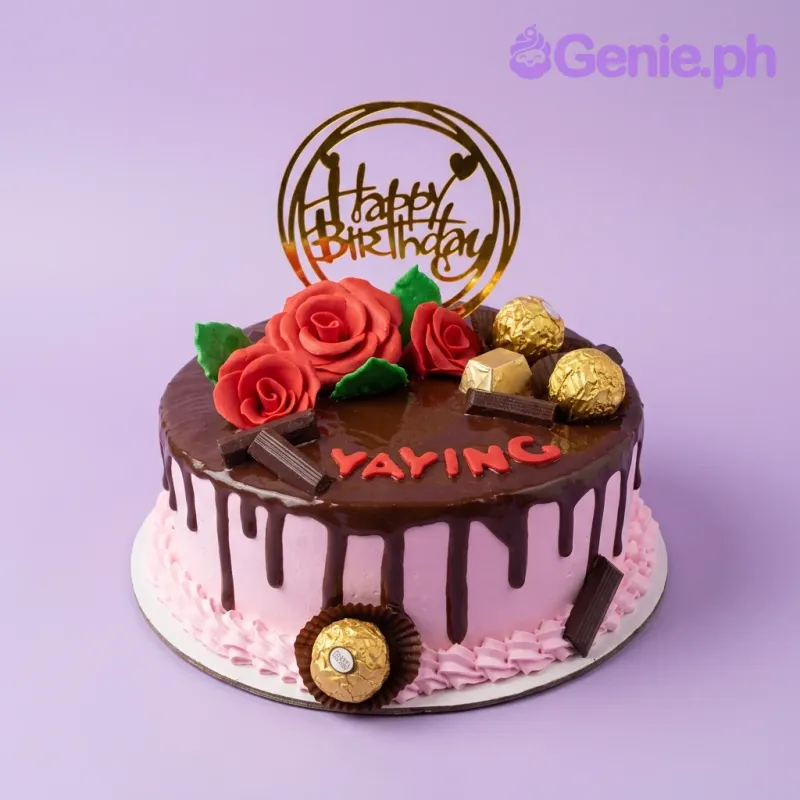 A pink 1-tier chocolate drip cake with red fondant roses, Ferrero Rocher chocolates, and a gold Happy Birthday topper. A pink 1-tier chocolate drip cake with red fondant roses, Ferrero Rocher chocolates, and a gold Happy Birthday topper.