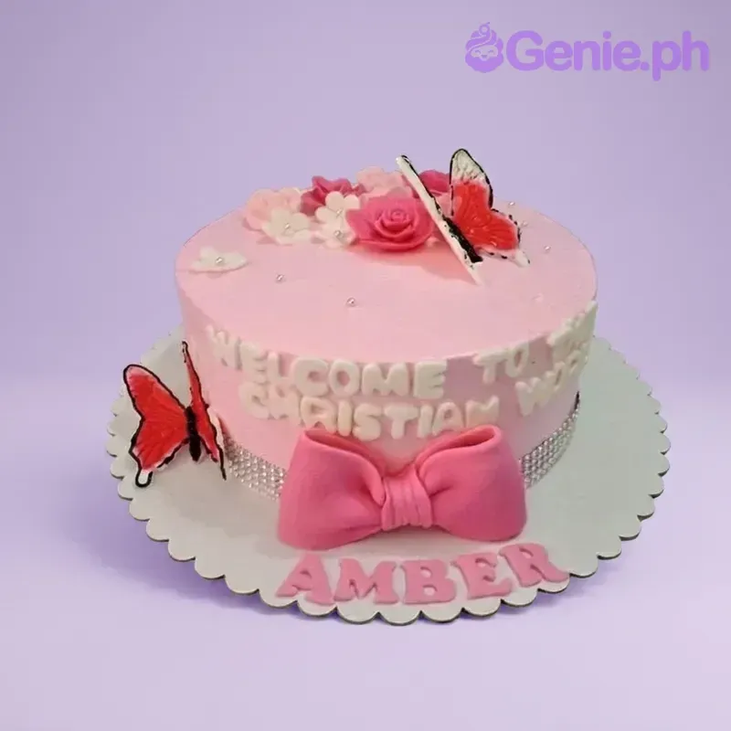 Pink Christianing cake with a large pink fondant bow, butterflies, and edible flowers on a soft pink icing base. Pink Christianing cake with a large pink fondant bow, butterflies, and edible flowers on a soft pink icing base.